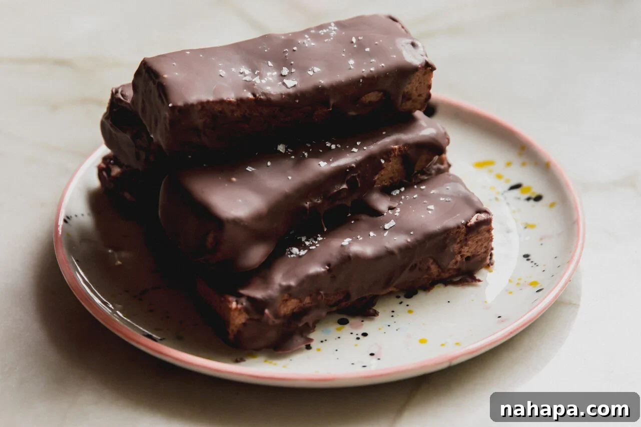 Brownie marshmallow protein bars stacked on top of each other on a plate.