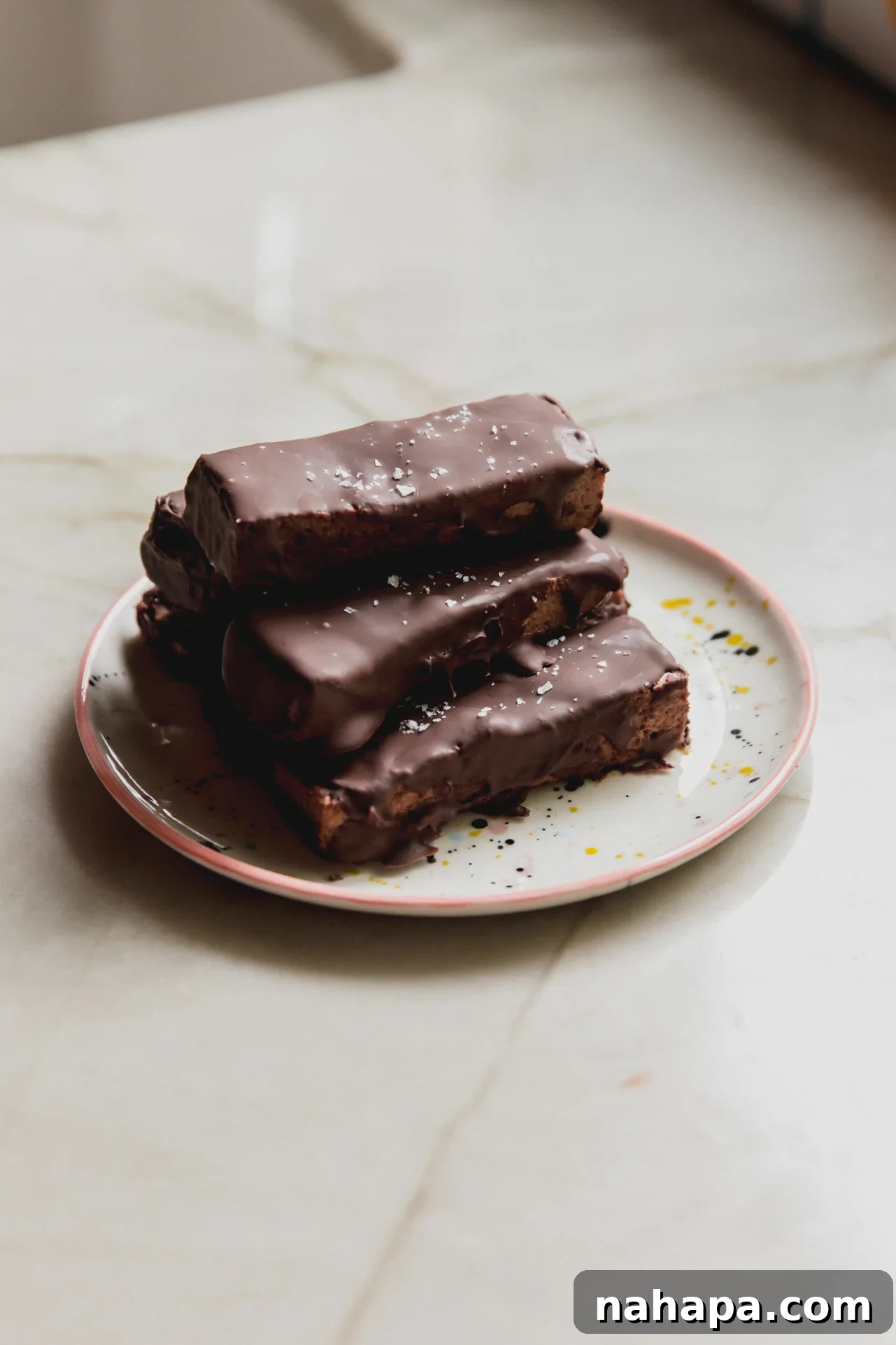 Brownie marshmallow protein bars stacked on top of each other on a plate.