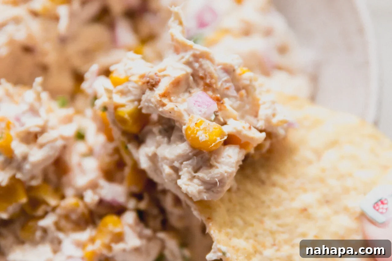 Mexican Street Corn Chicken Salad Recipe for Summer BBQs 8 A chip taking a chunk of street corn chicken salad from the bowl.