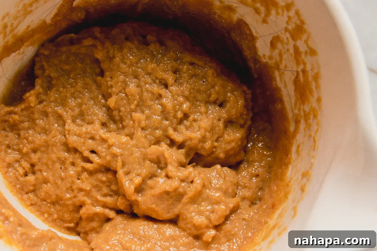 A white ceramic bowl filled with batter to make high protein muffins.