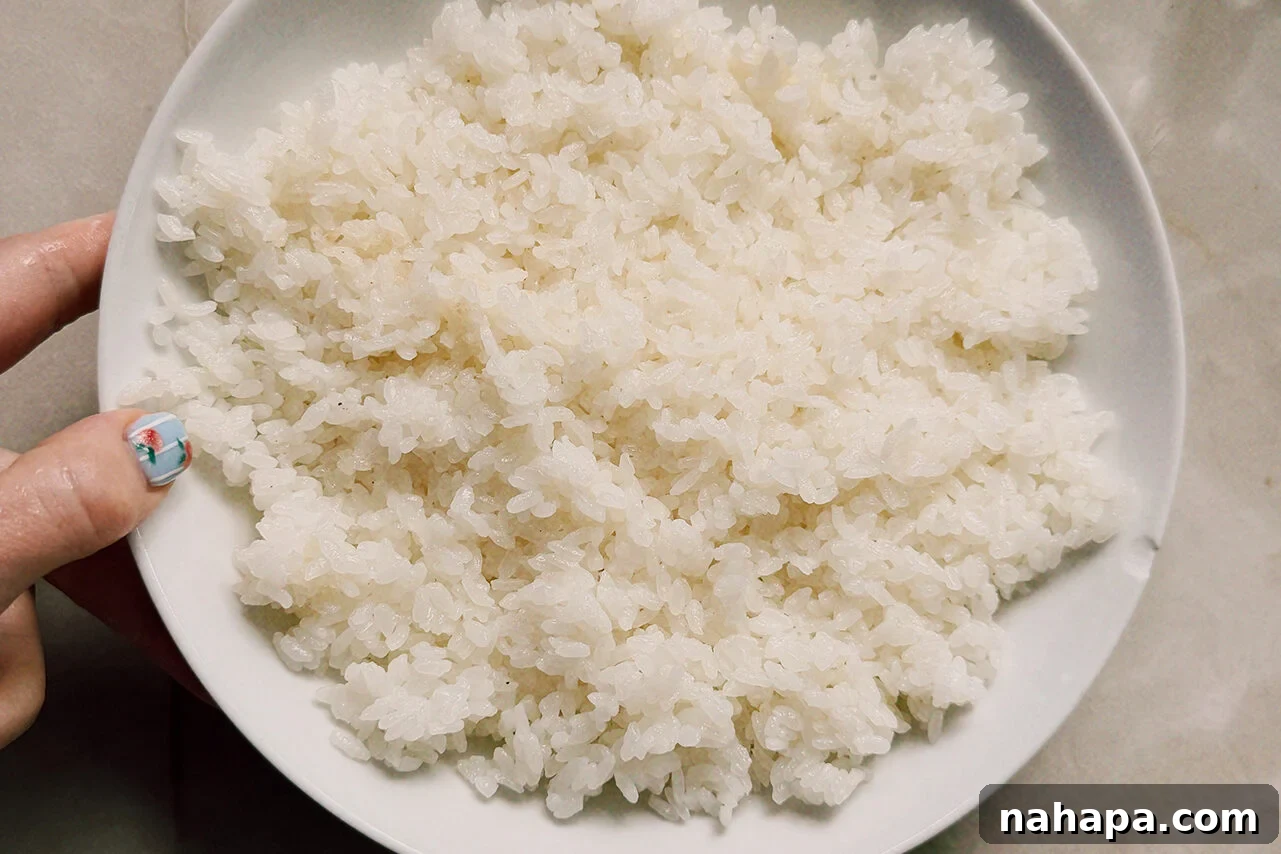 Tuna Onigiri Shaped Like Soccer Balls 4 A white bowl filled with rice mixed with vinegar.