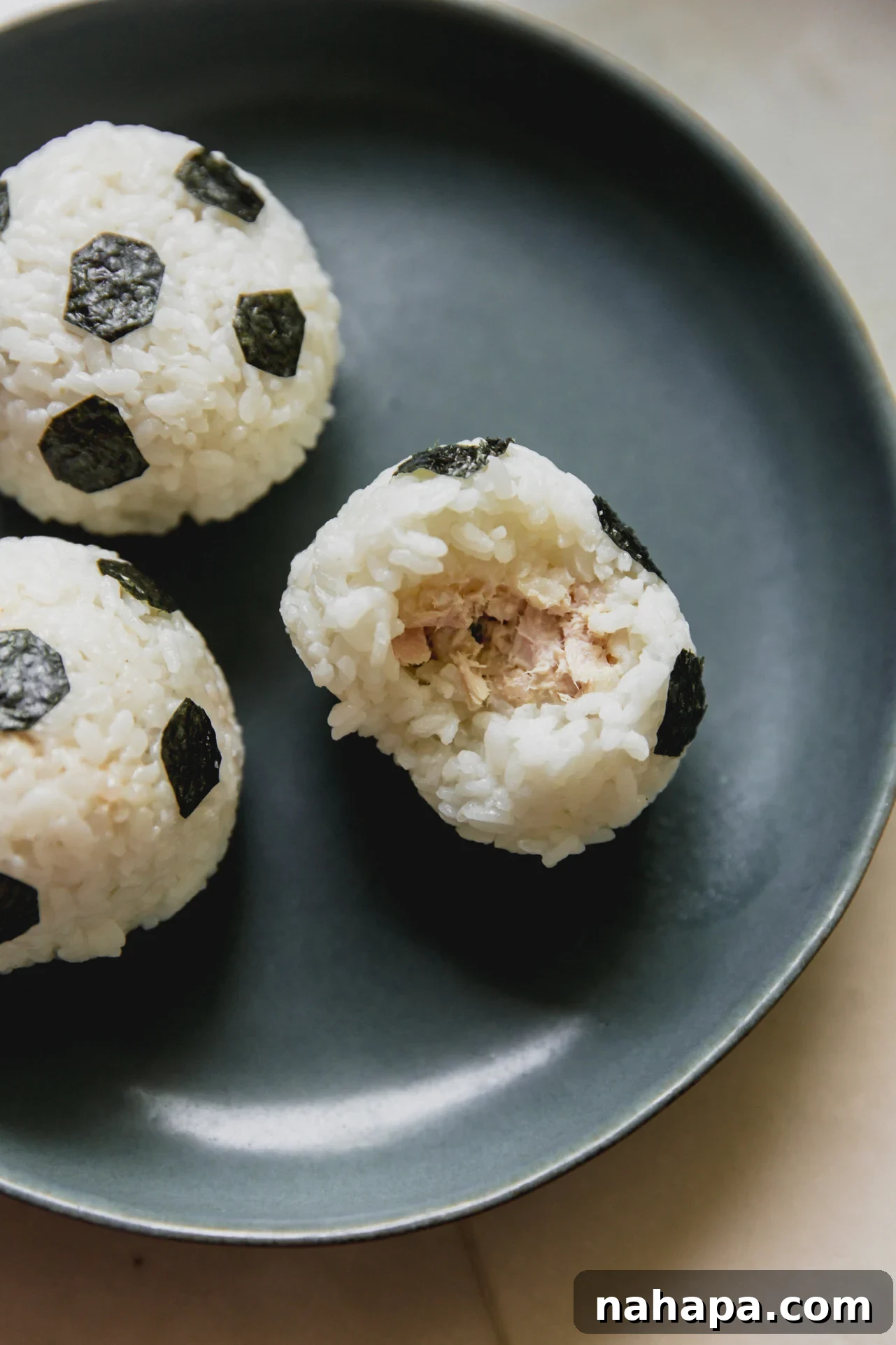 Tuna Onigiri Shaped Like Soccer Balls 9 Soccer tuna rice balls on a plate ready to serve.