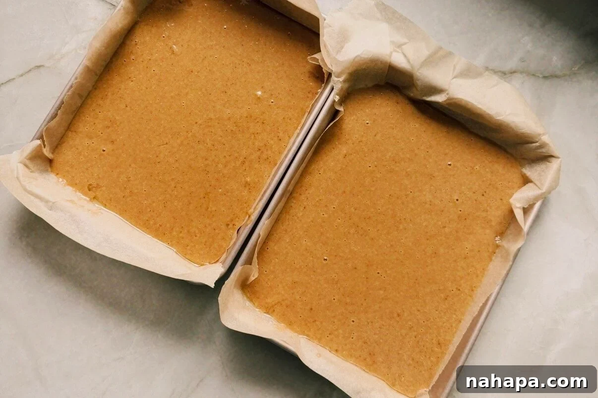 Two rectangular cake pans with cake batter.