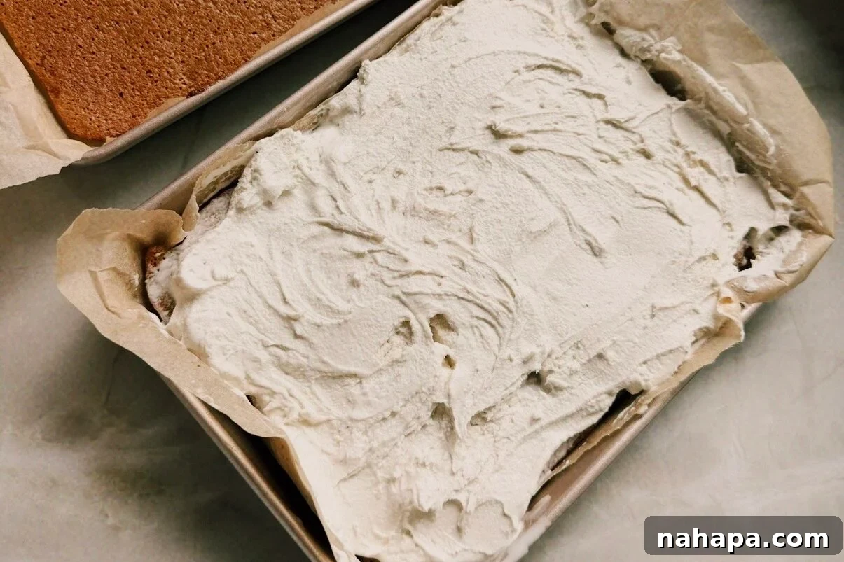 Two rectangular cake pans with cake, and one topped with ice cream.