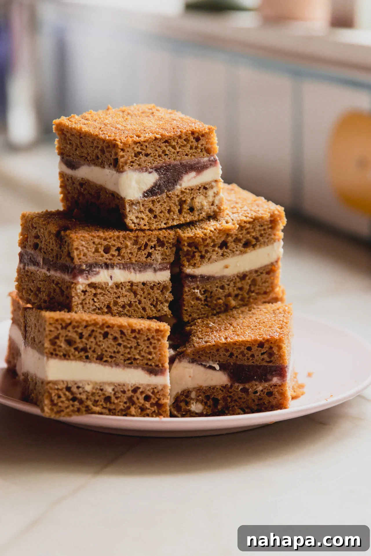Ice cream cake sandwich bars stacked on top of each other on a pink plate.