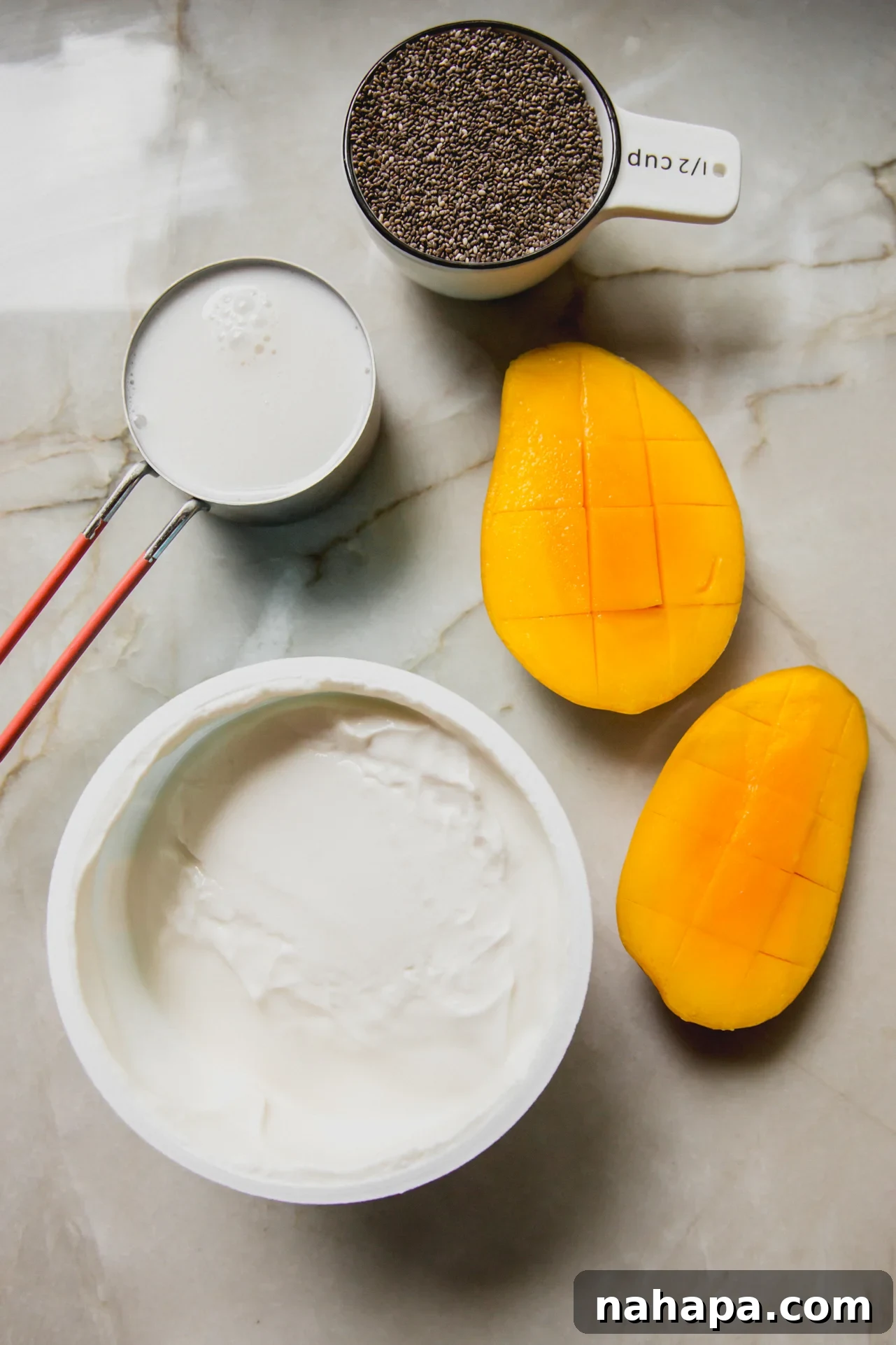 Mango chia pudding ingredients on a marble counter
