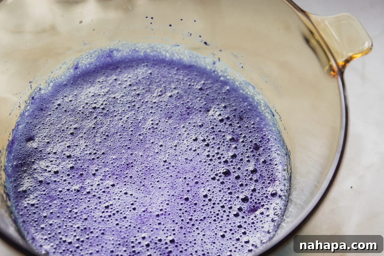 A glass bowl of blue raspberry mixture with gelatin.