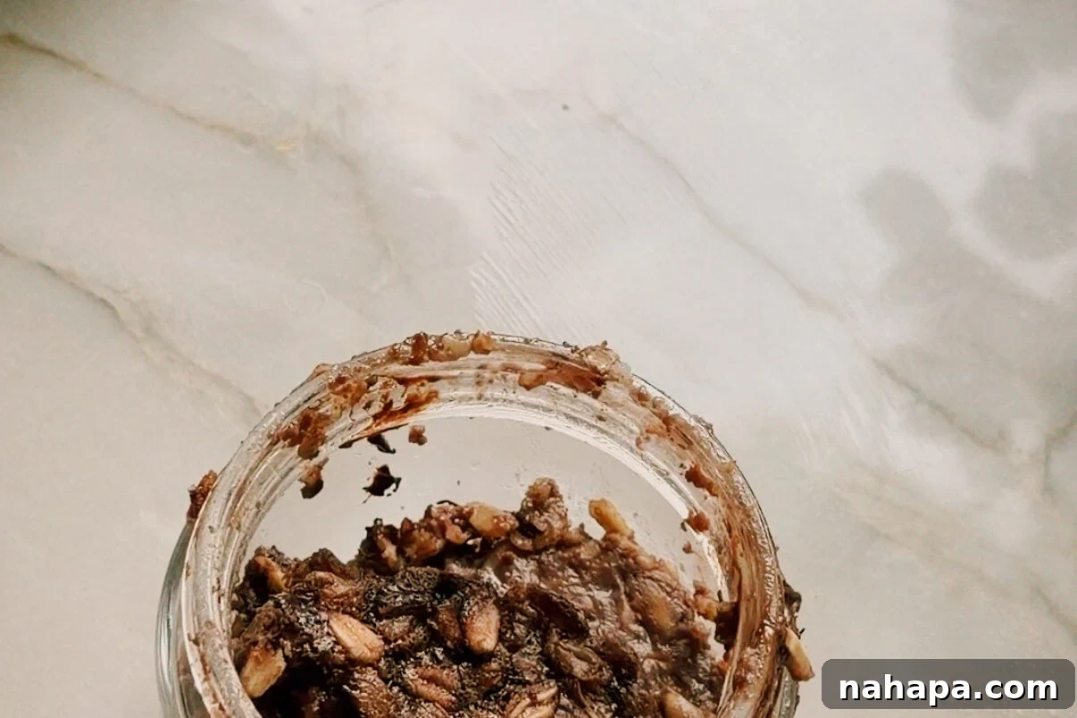 A glass jar with the baked oats layer added to it.