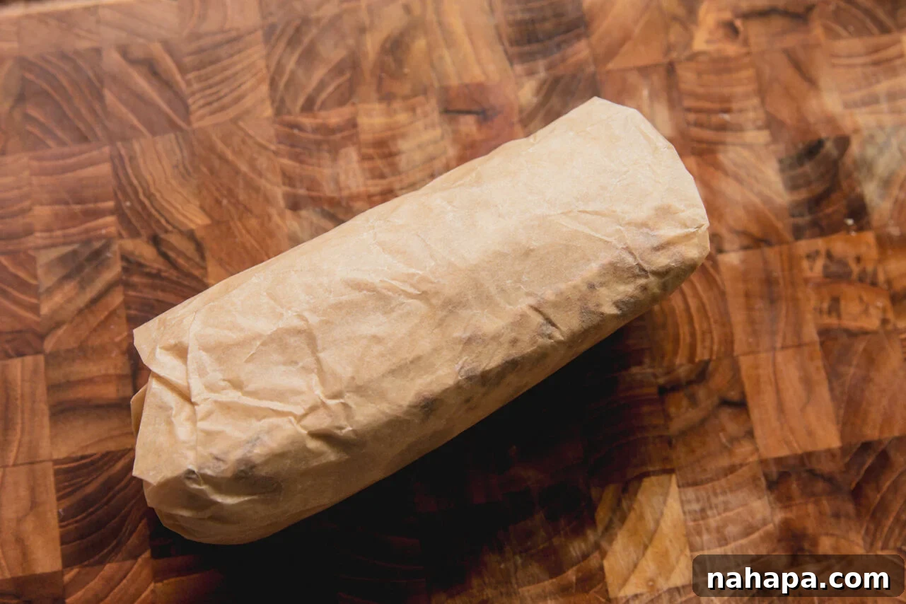 Caramelized Onion Breakfast Burritos with Eggs and Cheese 7 A caramelized onion breakfast burrito after being rolled with parchment paper.