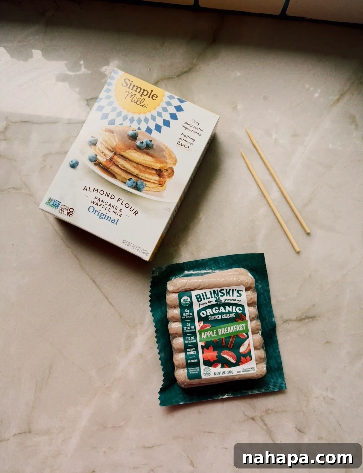 Gluten-Free Pancake and Sausage Sticks Recipe 4 A package of chicken apple sausages and pancake mix on a counter before cooking.