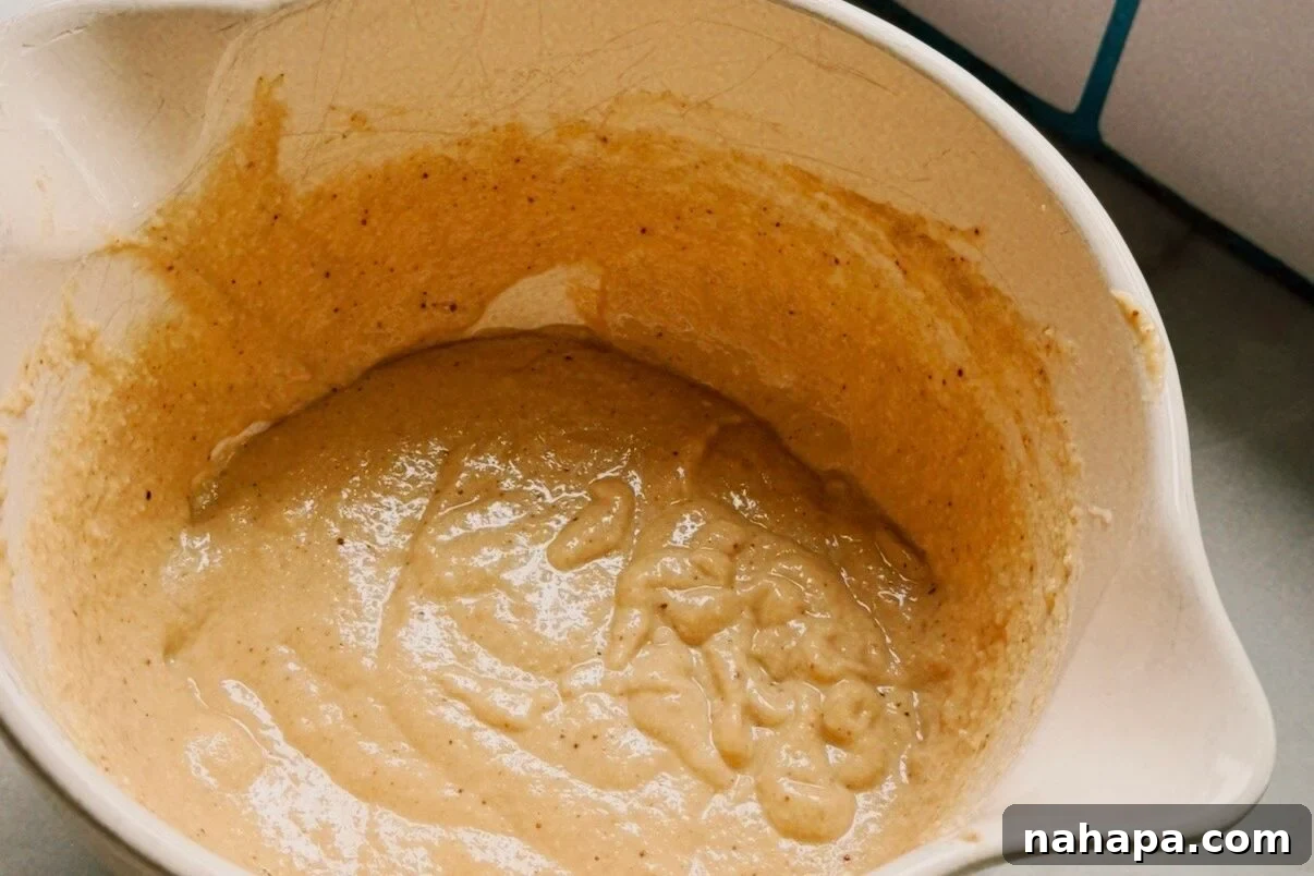 Gluten-Free Pancake and Sausage Sticks Recipe 5 A white ceramic bowl filled with pancake batter.