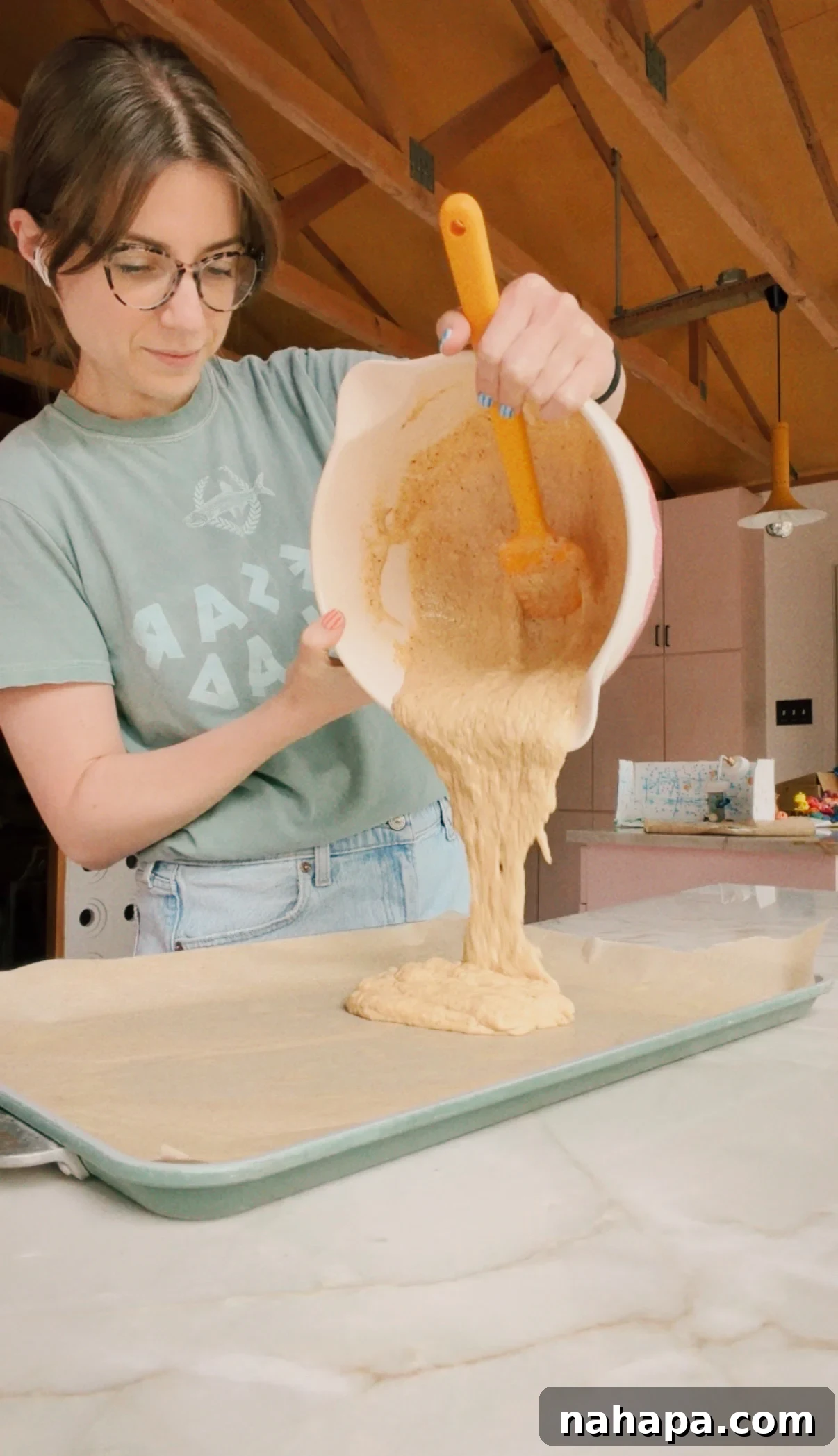Michelle pouring pancake mix onto a sheet pan.