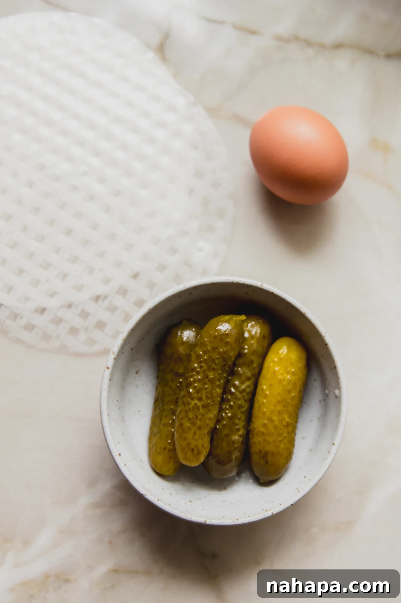 Pickles, rice paper and egg on a marble counter