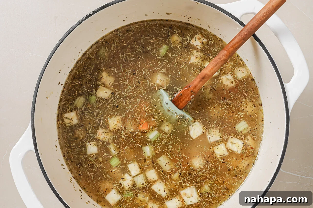 A Dutch oven filled with all the ingredients and broth.